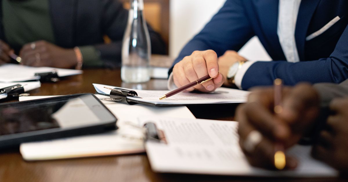 Business people reviewing documents and taking notes at a meeting table